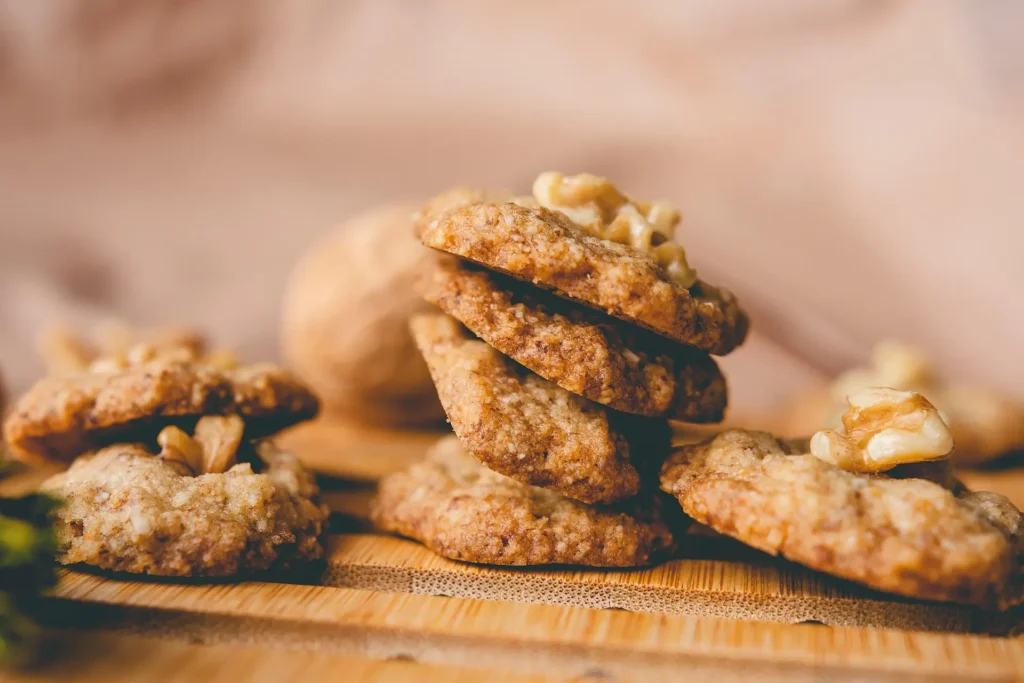 Homemade protein cookies on a cooling rack with ingredients in the background